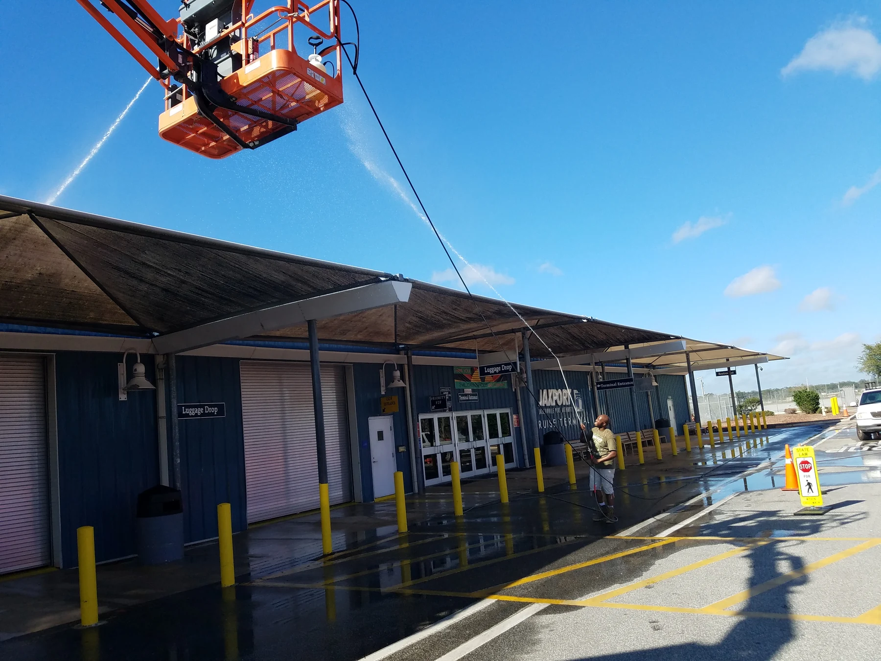 Safe Touch crew washing the JAXPORT Cruise Terminal canopy with a boom lift and ground equipment
