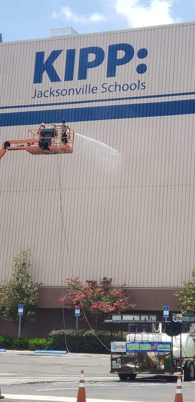 Safe Touch crew washing the KIPP Jacksonville Schools exterior from a boom lift