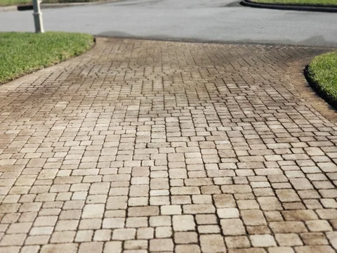 Paver driveway before cleaning with discoloration across the blocks and joints