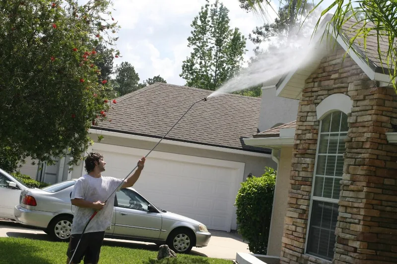 Safe Touch washing a residential roof and exterior during a real cleaning job